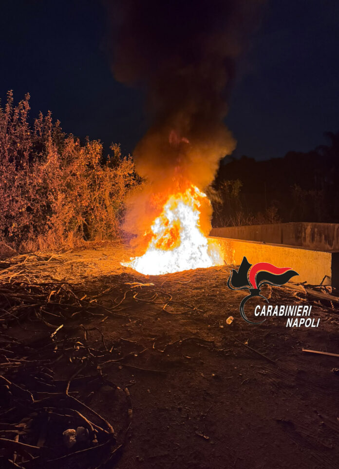 Incendio di plastica di notte con fiamme alte e fumo in un'area aperta natura.