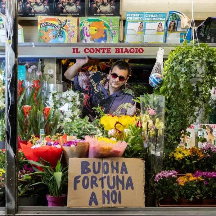 Il Conte Biagio in un negozio di fiori con cartello 