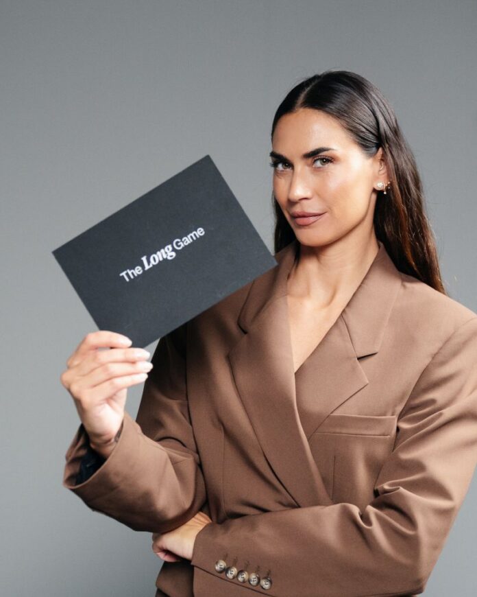 Melissa Satta tiene una cartellina nera con la scritta The Long Game, in un'immagine di archivio relativa al lancio del suo nuovo podcast sulla longevità.