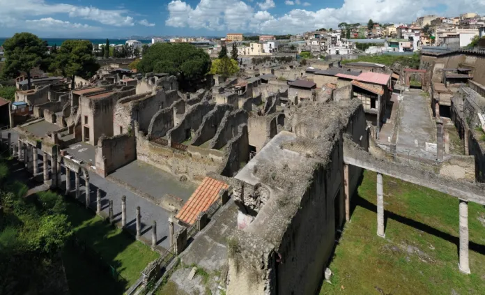 Veduta dall’alto di resti archeologici, con muri e ambienti in pietra.