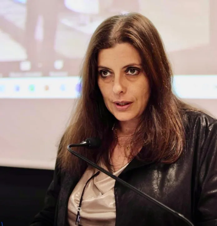 Donna che parla al microfono durante un evento.