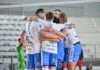 Union Napoli ospita Consoli Sferc Brescia, Raffaelli pronto alla sfida Un gruppo di pallavolisti in divisa si raccoglie in un abbraccio sul campo, con la rete sullo sfondo.